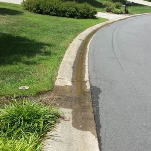 minor leak of water into gutter along residential street
