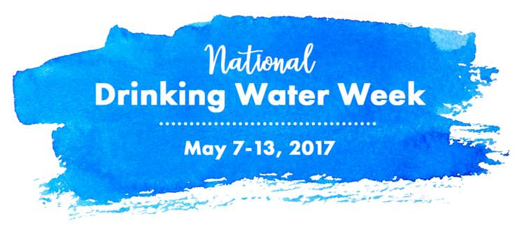 White sign with blue paint smear is background for white font in both cursive and regular font, National Drinking Water Week with a white dotted line before, May 7 to 13, 2017