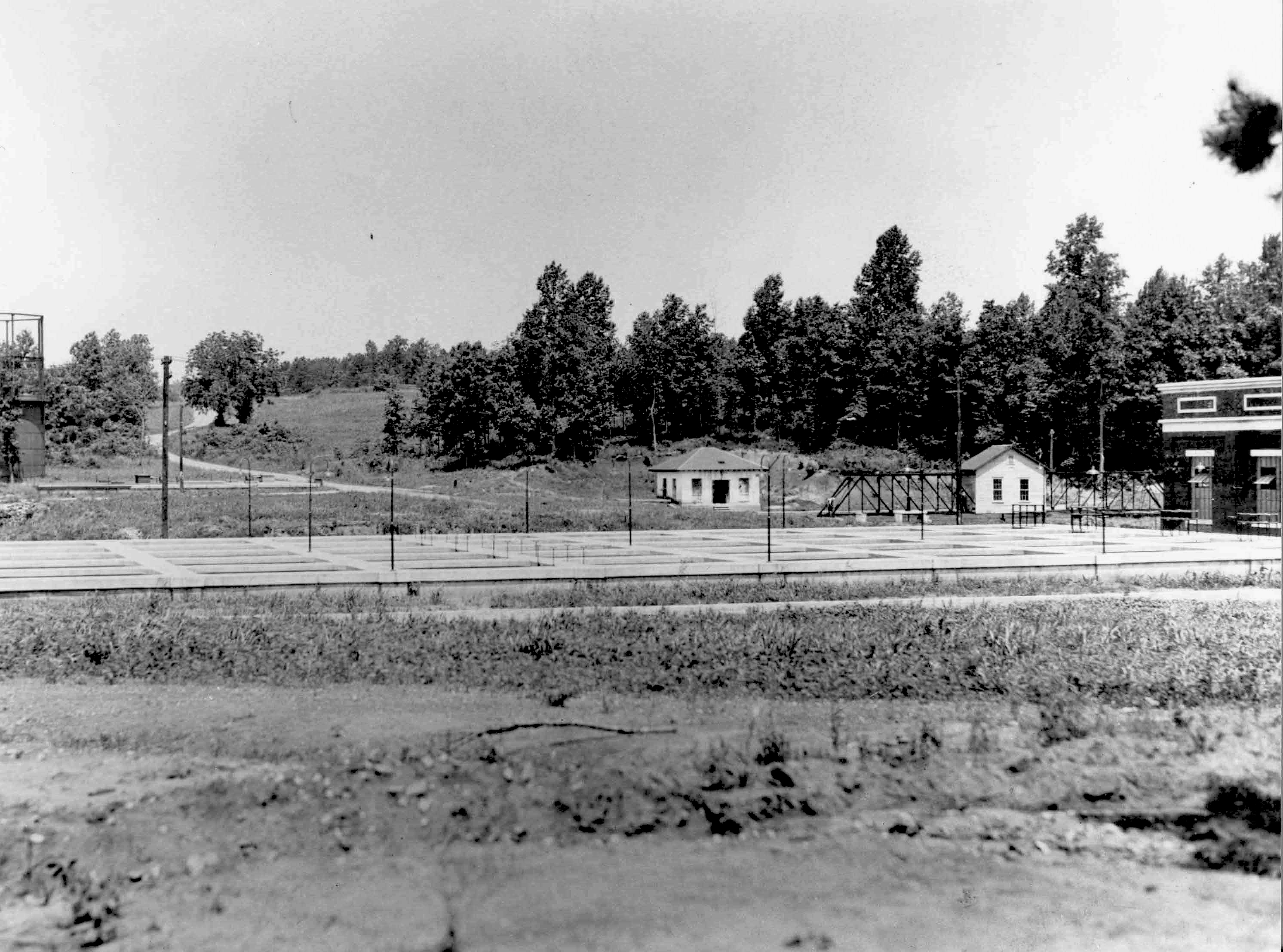 black and white vintage photo of a water treatment plant building and sediment ponds in an earlier era