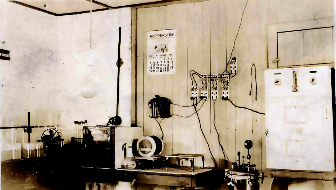 Vintage black and white photo of electrical panels and switches in a water treatment plant from years ago