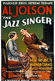 movie poster for the vintage film The Jazz Singer depicting iconic actor Al Jolson playing a piano