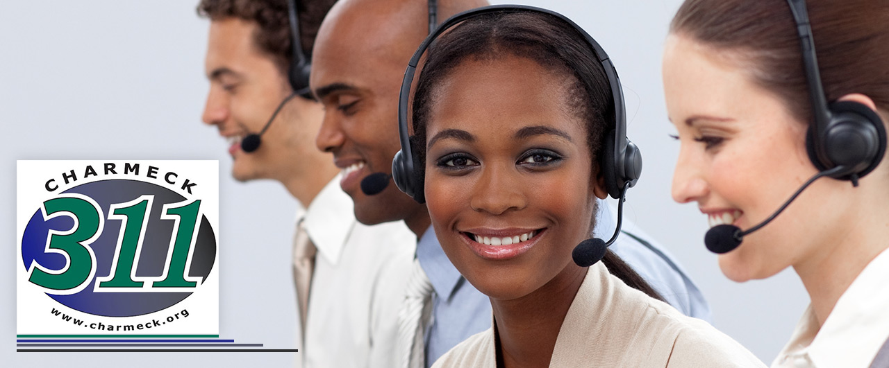promotional photo of the faces of 4 customer care agents with headphones and the Charmeck 311 logo on the left side of image