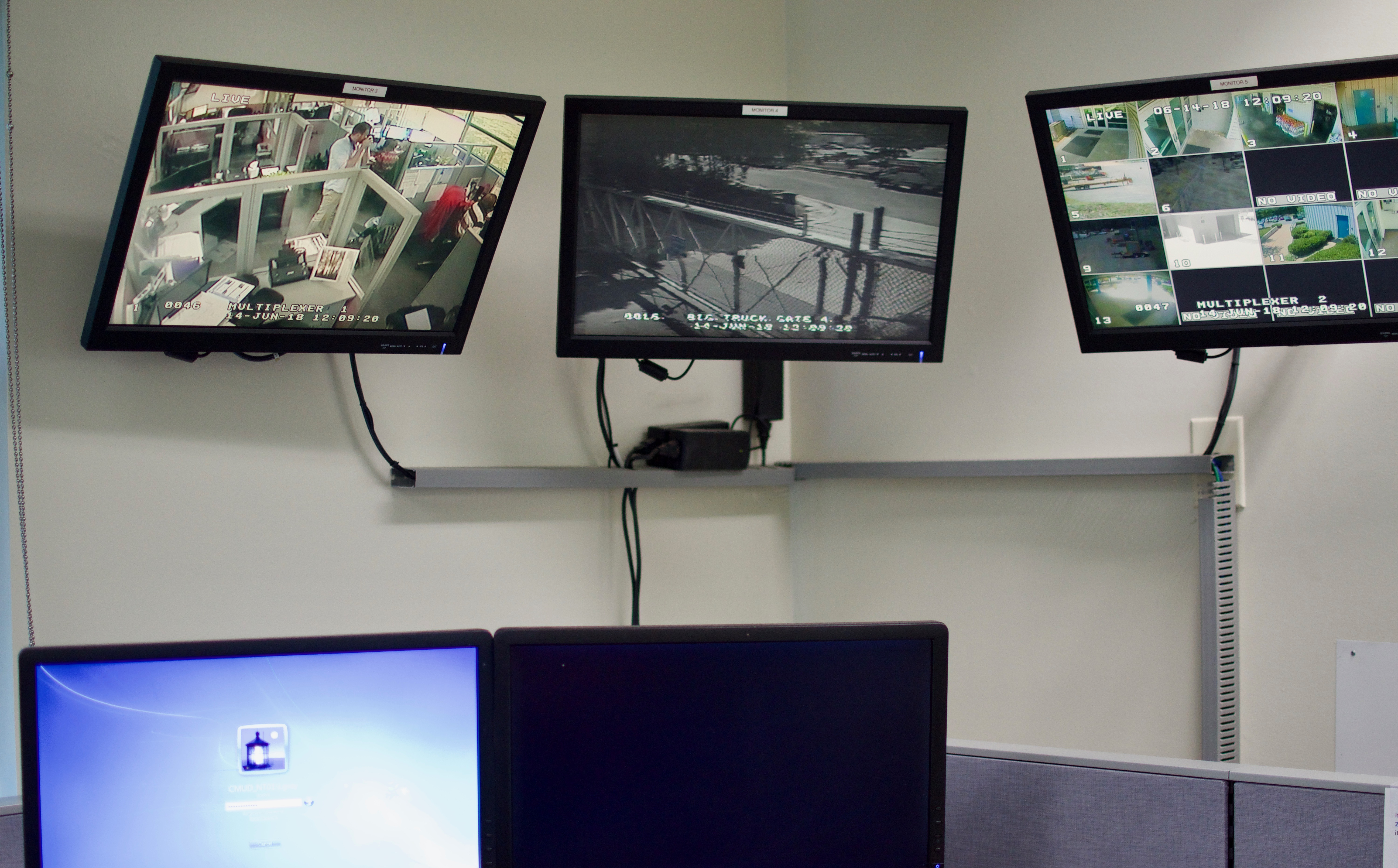 a rack array of black-framed multiple monitors displays security images from throughout and around a building