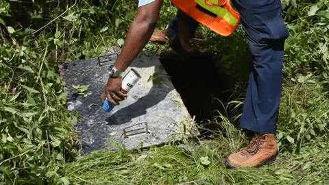 video clip of a utility technician spraying blue paint on a meter box lid