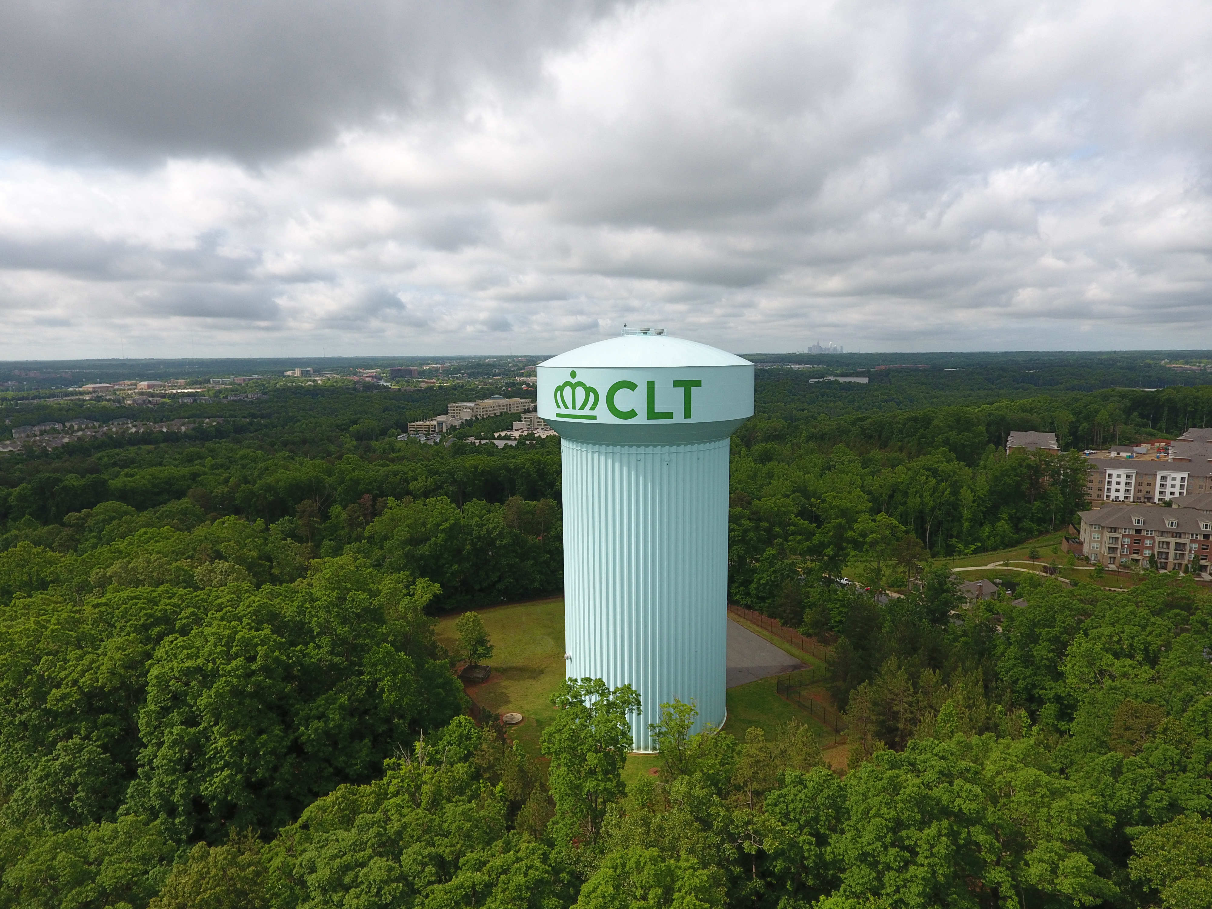 panoramic view of light green, twenty-story mushroom shaped water tower with county logo and initials in green font CLT