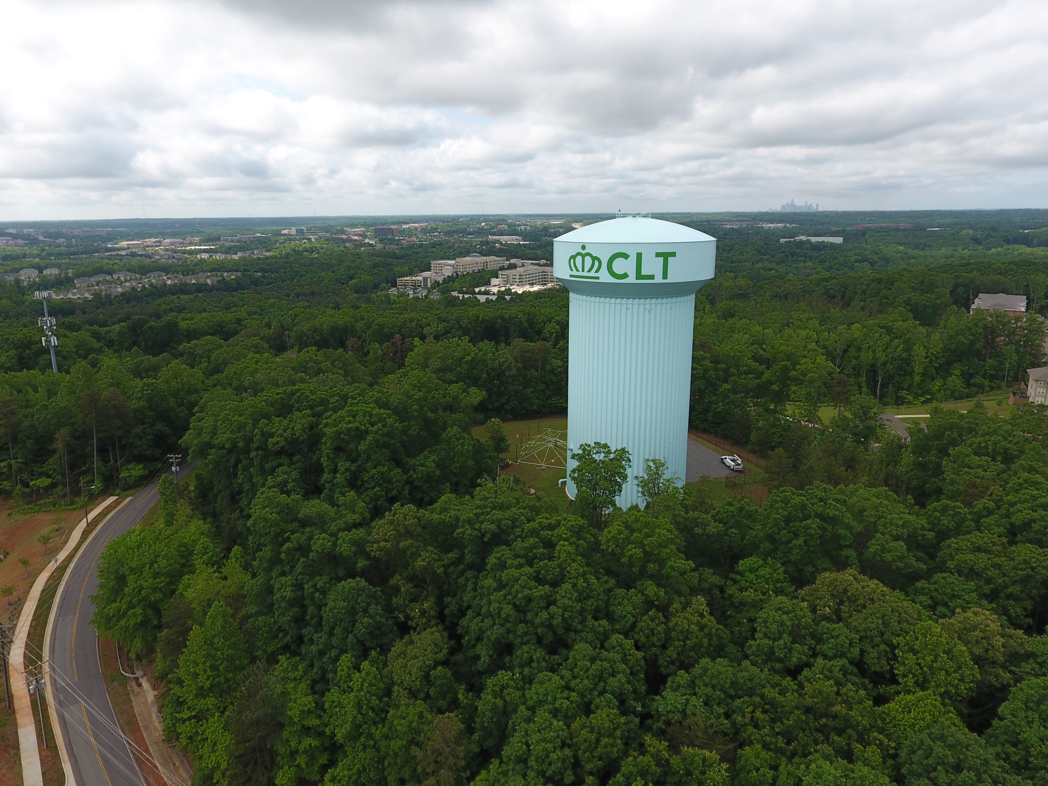 panoramic view of light green, twenty-story mushroom shaped water tower with county logo and initials in green font CLT