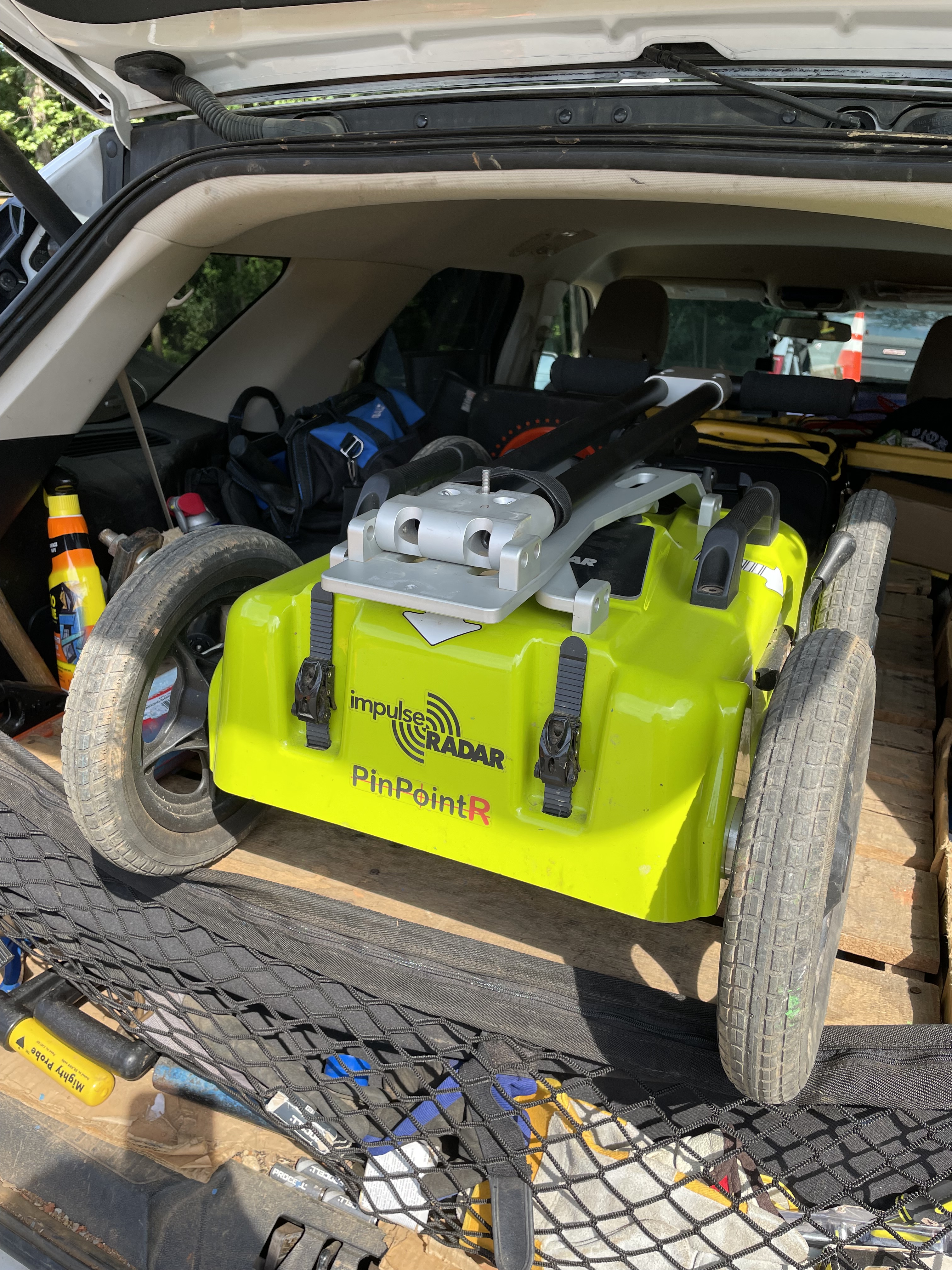lime yellow robotic radar device with 4 wheels sits ready for deployment in the back of an SUV
