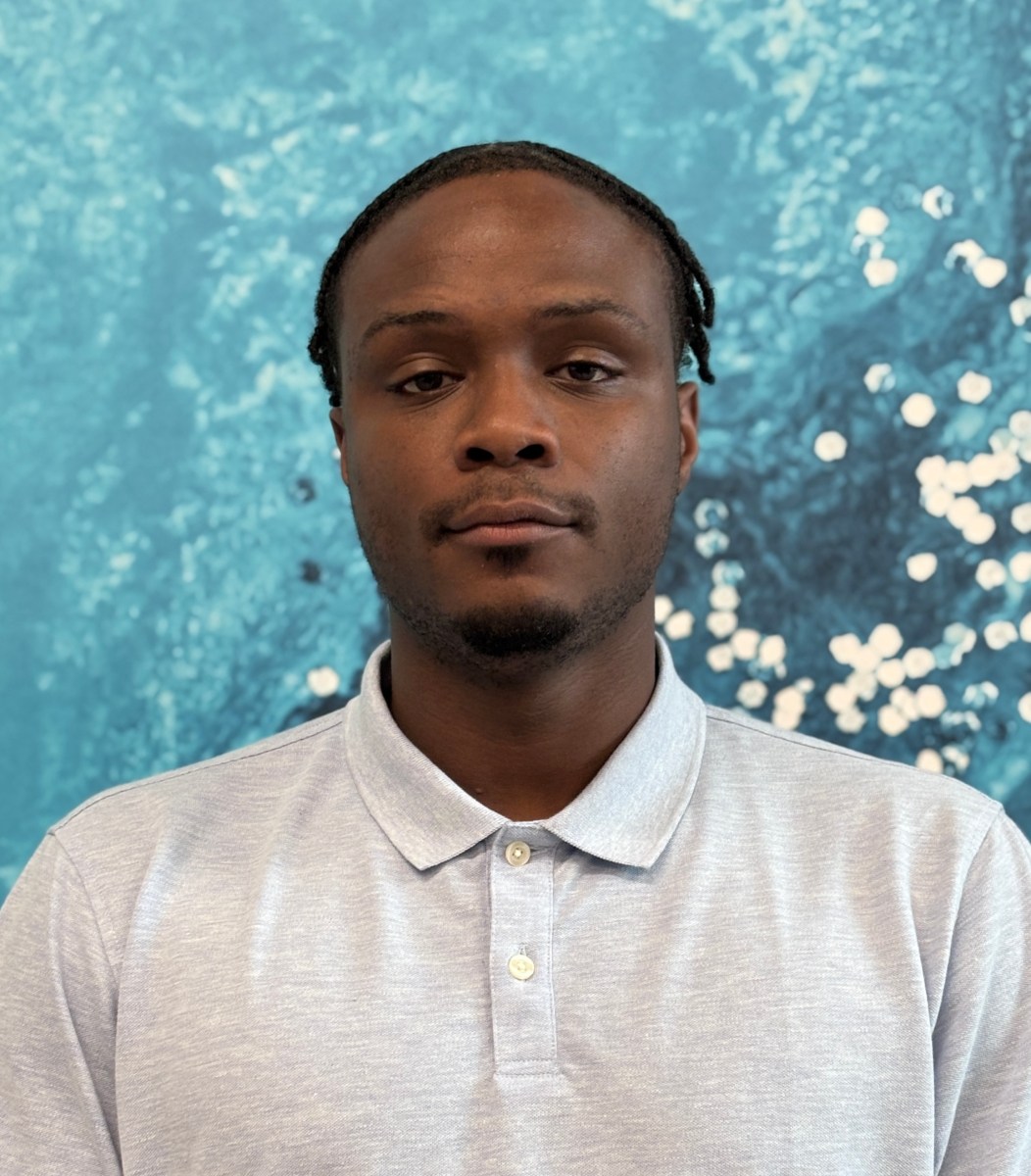Profile photo of utility technician apprentice with short, dark brown, braided hair wearing a light grey polo shirt